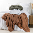 Blankets stacked on bed