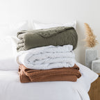 Blankets stacked on bed