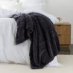 Charcoal Colour Embossed fleece blanket styled on the end of bed