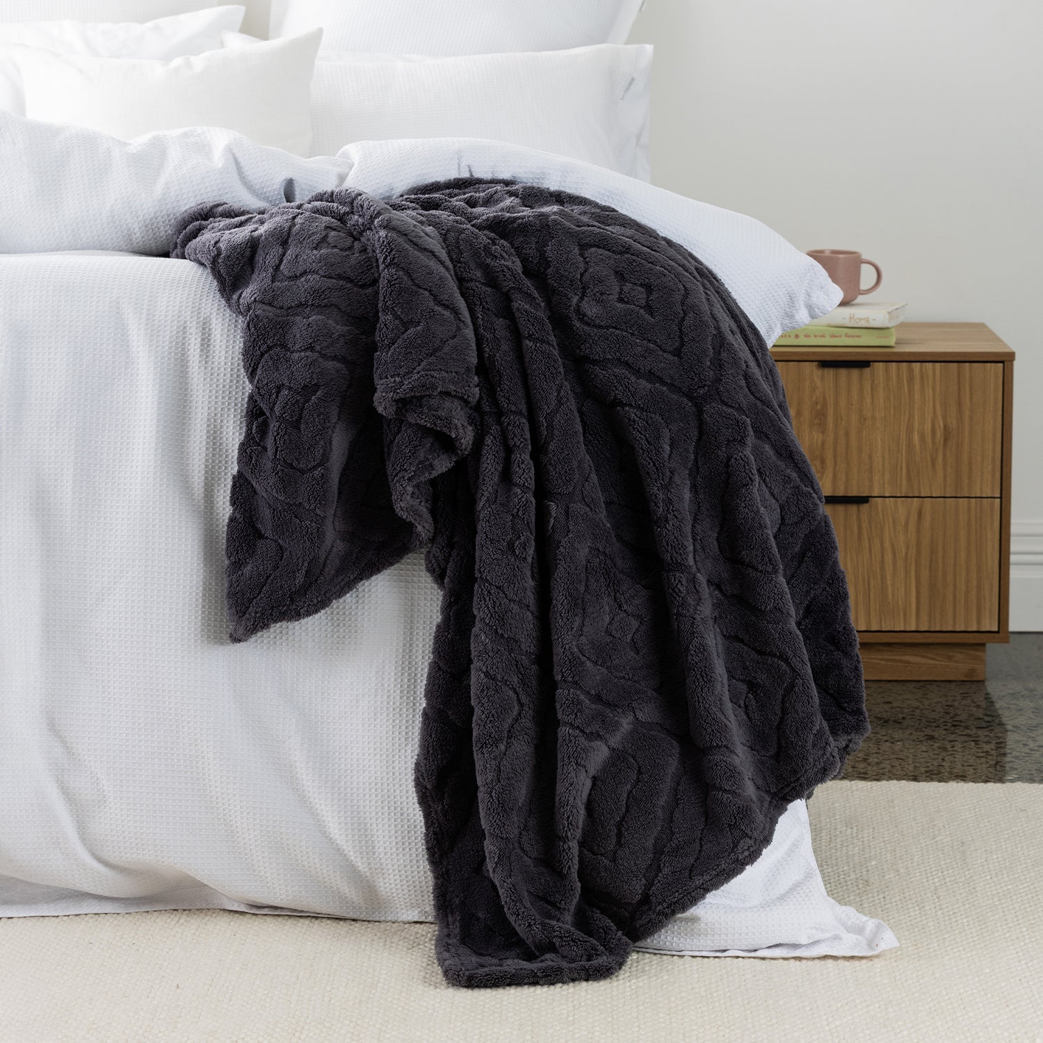 Charcoal Colour Embossed fleece blanket styled on the end of bed