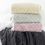 Stack of 4 Embossed fleece blankets styled on the end of bed