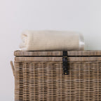 Woolrest Woolcell glacier blanket folded on a wicker basket.