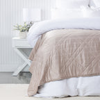 Bambou Summer Blanket in Mushroom styled on a white bed, showing the soft neutral colour and diamond quilting.