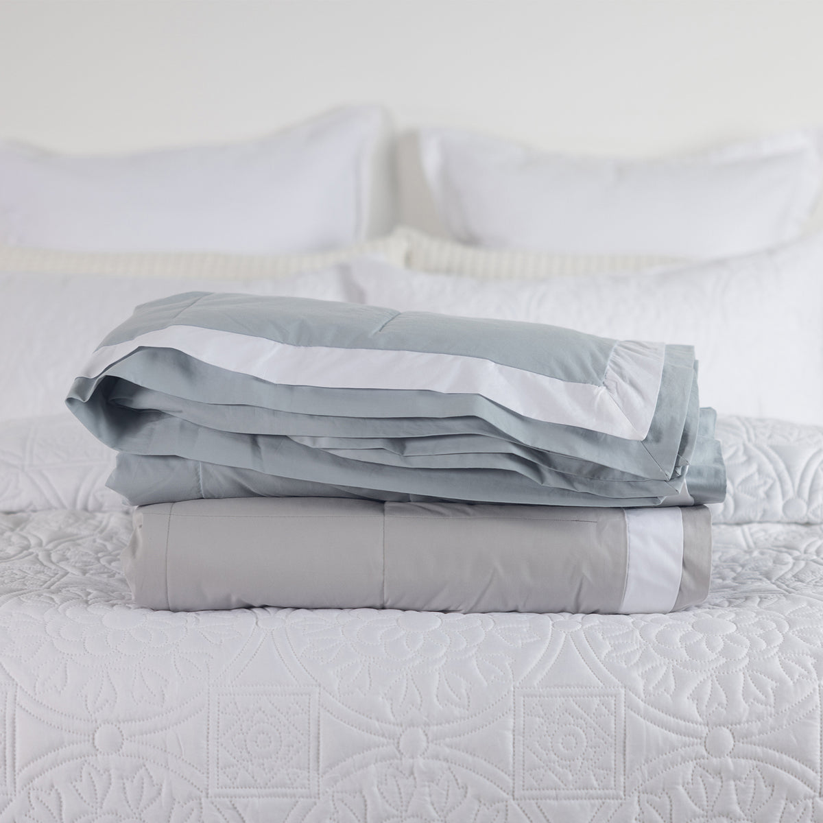 folded blankets on a bed Pebble & Duck egg.