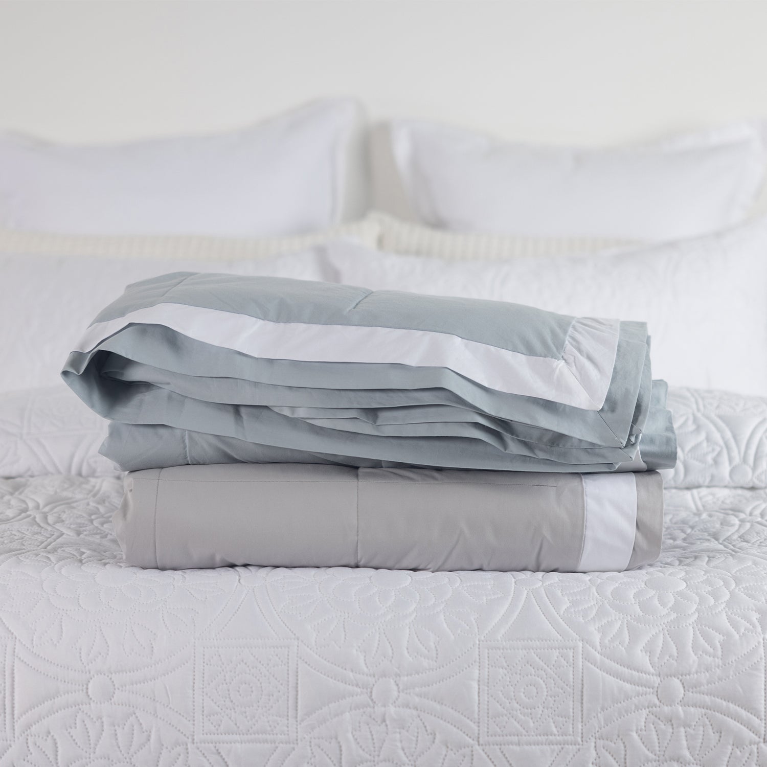 folded blankets on a bed Pebble & Duck egg.