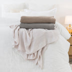 Mocha, Dove and Linen aircell blankets styled together on a white bed, showcasing their textured waffle weave and soft tonal colours.