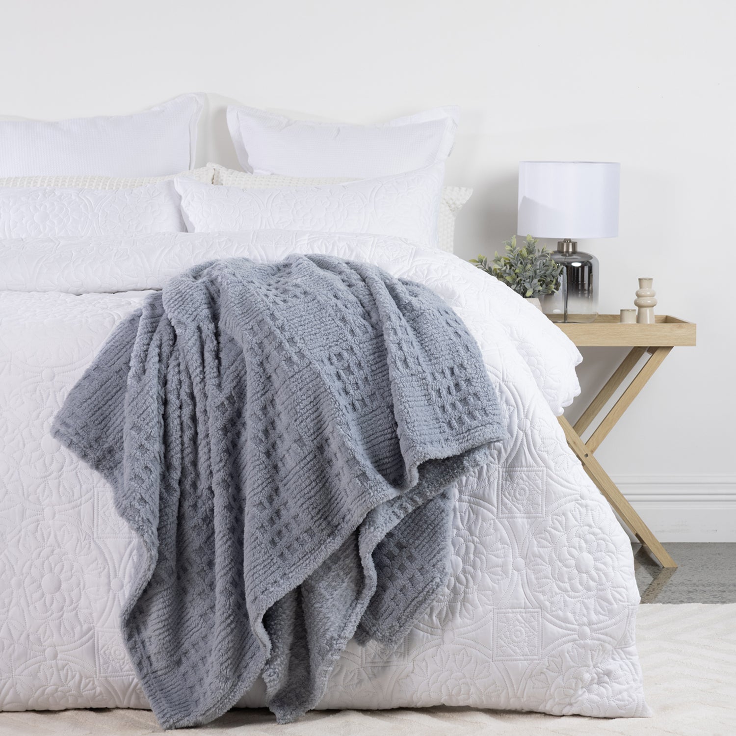 Solace Trellis Blankets styled on a white bed, featuring Driftwood, Silver Blue and White colourways with textured trellis detailing.
