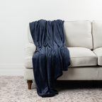 Navy Home Co. Super Plush Blanket styled over a neutral sofa, showing its deep navy colour and plush finish.