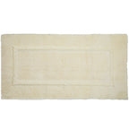 Cream bathmat with a soft plush texture and subtle rectangular border detailing.