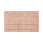 Blush pink bathmat featuring a soft tufted grid design on a clean white background.