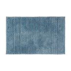 Pale blue striped bath mat with soft textured pile on a white background.
