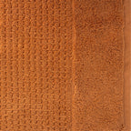 Close-up of caramel Fieldcrest Marney textured hand towel showing the raised woven pattern and soft cotton pile.