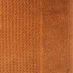 Close-up of caramel Fieldcrest Marney textured hand towel showing the raised woven pattern and soft cotton pile.