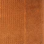 Close-up of caramel Fieldcrest Marney textured hand towel showing the raised woven pattern and soft cotton pile.