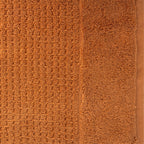 Close-up of caramel Fieldcrest Marney textured hand towel showing the raised woven pattern and soft cotton pile.