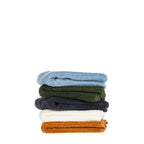 Side view of folded Fieldcrest Marney textured face cloths stacked in blue, green, charcoal, ivory, and caramel.