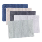 Five textured bath mat in different colors, stacked in an overlapping fan arrangement on a solid white background. The colors are Navy, taupe, Silver, Ebony & Sage.