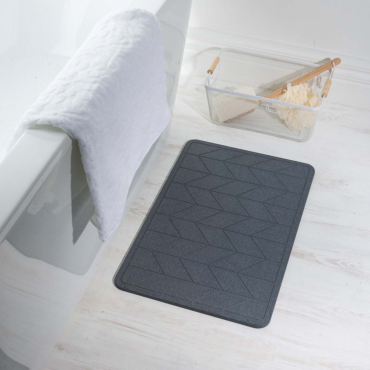 Charcoal stone quick dry bathmat featuring a modern geometric pattern, styled beside a bathtub in a bright contemporary bathroom setting.