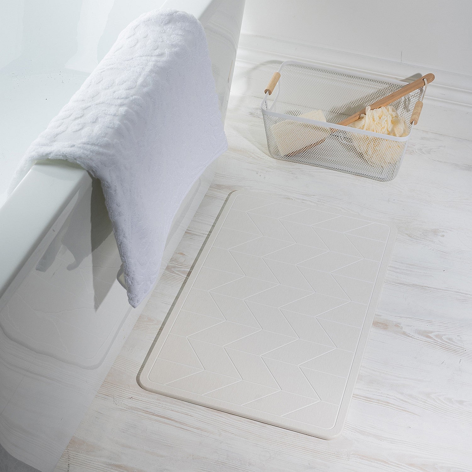 White quick dry Stone bathmat featuring a modern geometric pattern, styled beside a bathtub in a bright contemporary bathroom setting.