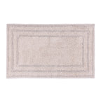 Taupe rectangular bath mat with a plush textured surface and layered border detailing.