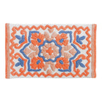 White floral bathmat featuring a decorative clay orange, peach and blue tufted pattern with a coordinating border.