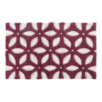 Chocolate bathmat featuring a repeating geometric floral pattern in cream and soft mauve tones.