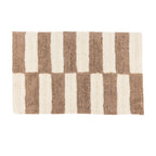 Bathmat featuring a bold striped tufted design in warm taupe and cream tones on a clean white background.