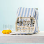 A picnic backpack with a built-in cutlery organizer, shown open with plates & plastic glasses.