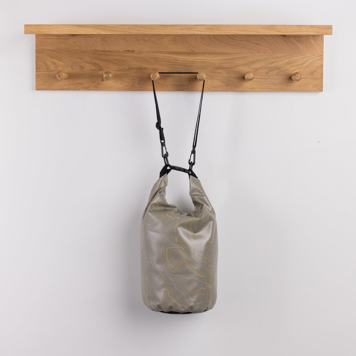 Seaside Supplies Waterproof Beach Bag 8L Map Grey featuring a neutral grey design with fine yellow and white contour-style lines, a roll-top closure and adjustable black shoulder strap.