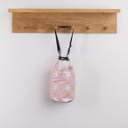 Seaside Supplies Waterproof Beach Bag 5.8L Flowers Peach featuring a soft peach-pink design with white daisies and small orange hearts, finished with a roll-top closure and black shoulder strap.