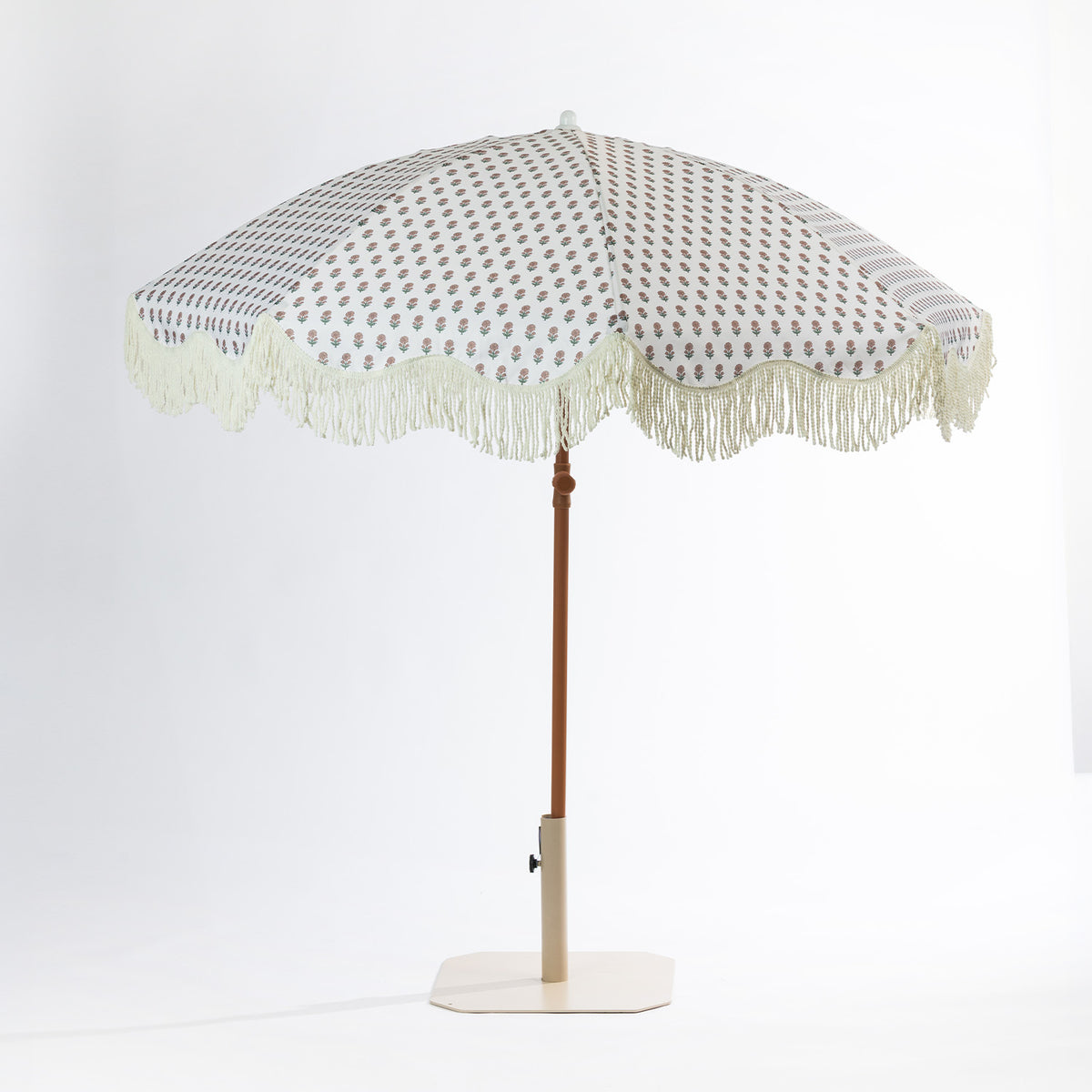 Seaside Supplies floral outdoor umbrella shown front-on with a cream patterned canopy, scalloped fringe trim, brown pole and cream base.