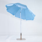 Seaside Supplies Blue Beach Umbrella shown open and tilted, revealing the light blue underside, white support ribs and adjustable pole against a white background.