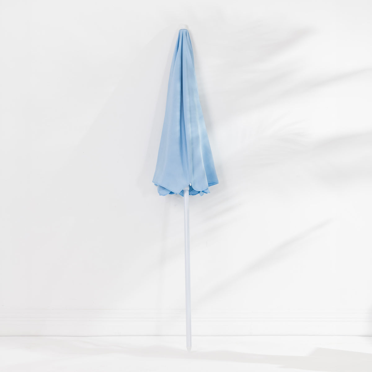 Seaside Supplies Blue Beach Umbrella featuring a folded light blue canopy and white pole, displayed upright against a white background.