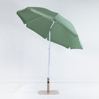 Seaside Supplies Olive Beach Umbrella shown open and tilted, revealing the sage green underside, white support ribs and adjustable pole against a white background.