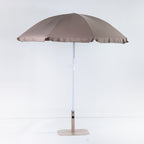 Seaside Supplies Chocolate Beach Umbrella featuring an open chocolate-brown canopy with a white adjustable pole and beige display stand against a white background.