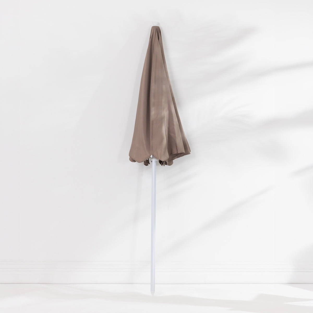 Seaside Supplies Chocolate Beach Umbrella featuring a folded taupe-brown canopy and white pole, displayed upright against a white background.