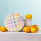 A round  2 person picnic set on a white wooden table, styled with lemons and oranges against a light blue background.