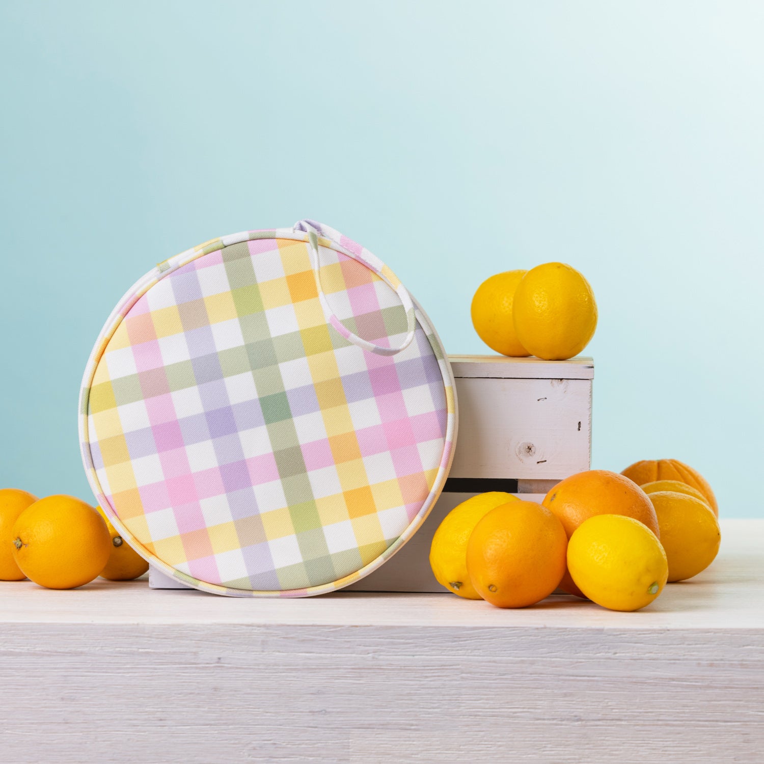 A round  2 person picnic set on a white wooden table, styled with lemons and oranges against a light blue background.