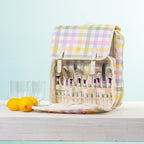 A picnic backpack with a built-in cutlery organizer, shown open with plates & plastic glasses.