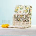 A picnic backpack with a built-in cutlery organizer, shown open with plates & plastic glasses.