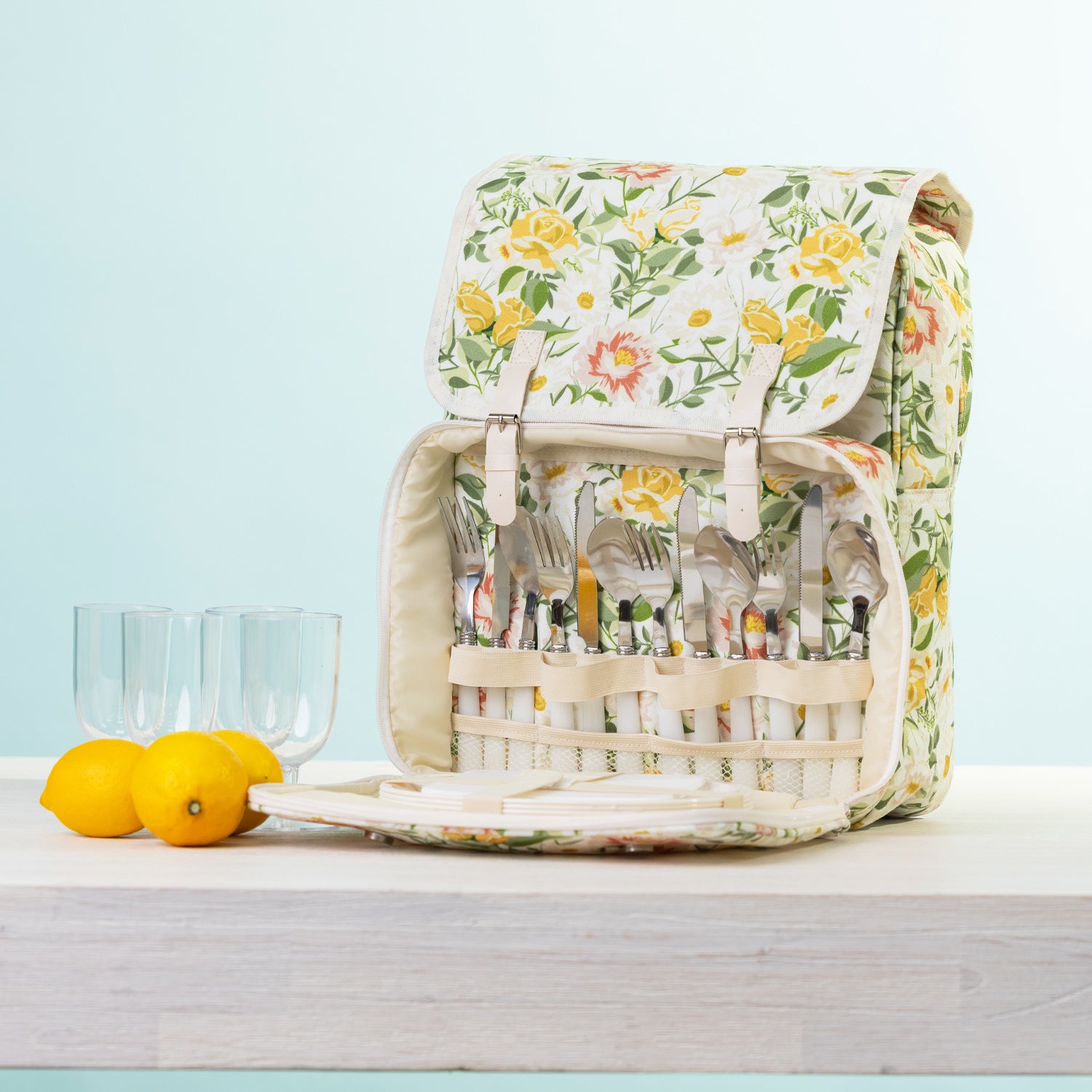 A picnic backpack with a built-in cutlery organizer, shown open with plates & plastic glasses.