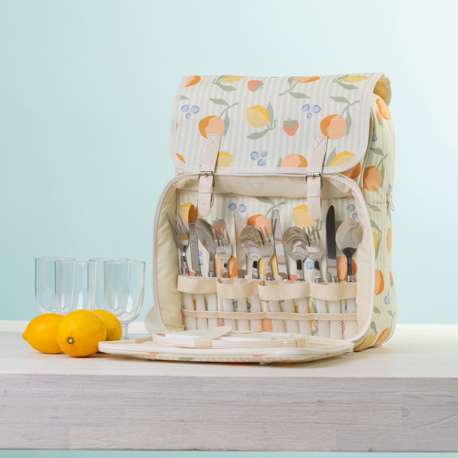 A picnic backpack with a built-in cutlery organizer, shown open with plates & plastic glasses.