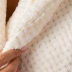 Close-up of the cream textured plush bathrobe highlighting the ultra-soft fabric, textured finish and plush shawl collar.