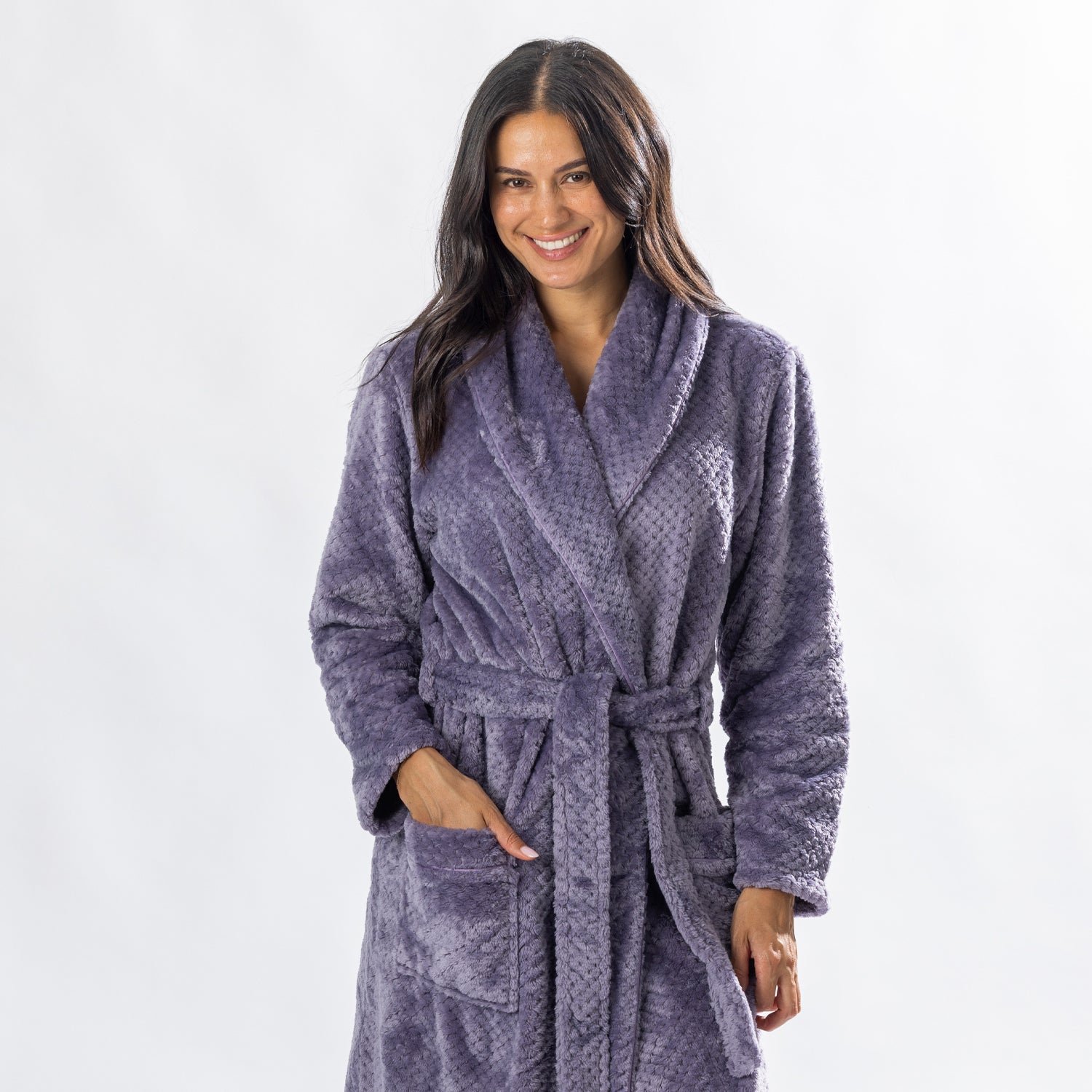 Woman wearing a Lavender textured plush bathrobe with a shawl collar, self-tie belt and patch pockets.