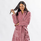 Woman wearing a Rose textured plush bathrobe with a shawl collar, self-tie belt and patch pockets.