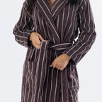 Close-up of a chocolate brown striped towelling robe showing the tie belt, shawl collar, long sleeves and front patch pockets.