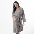 A woman modeling a brown and white gingham check robe with a tie belt, standing against a plain white studio background.
