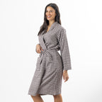 A woman modeling a brown and white gingham check robe against a plain white studio background.