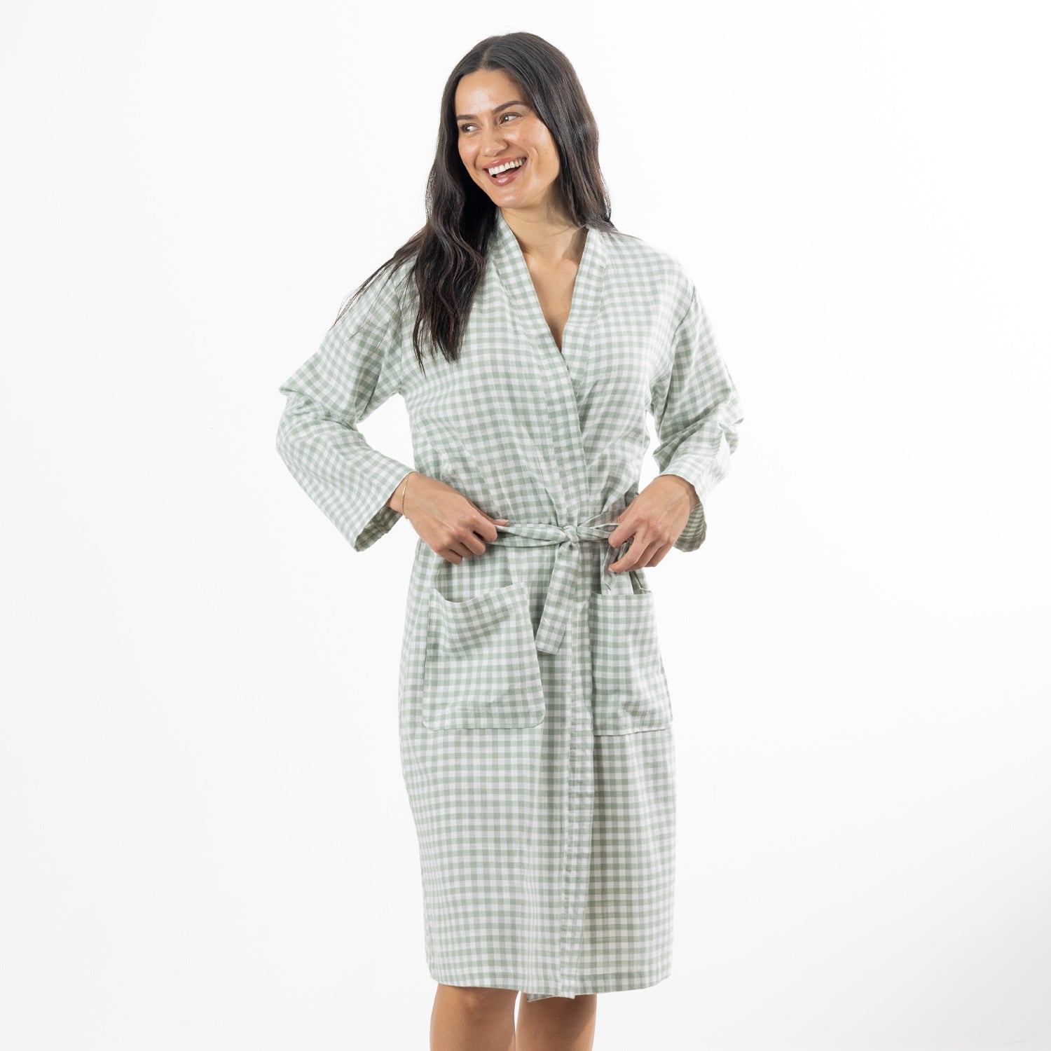 A woman models a soft sage green gingham robe featuring a wrap-front design, waist tie and roomy patch pockets.