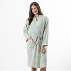 A woman models a soft sage green gingham robe featuring a wrap-front design, waist tie and roomy patch pockets.
